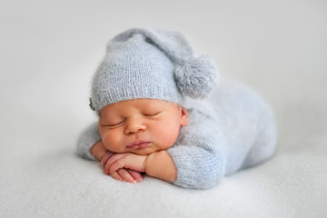 Sleeping newborn boy in the first days of life on white background - obrazy, fototapety, plakaty