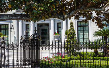 A plaster Mansion Past Wrought Iron fence in Savannah