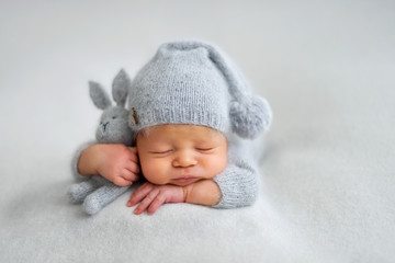 Sleeping newborn boy in the first days of life on white background - obrazy, fototapety, plakaty