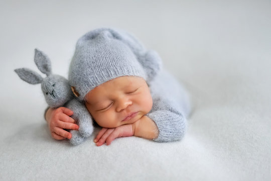 Sleeping newborn boy in the first days of life on white background