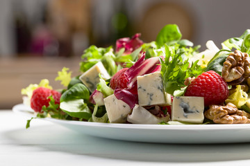 Green salad with blue cheese, raspberry and walnuts.
