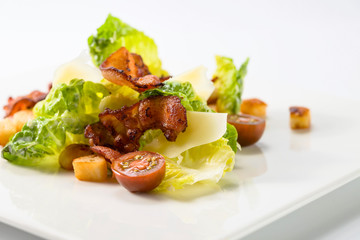 Caesar salad with tomatoes ,toasts  and bacon.
