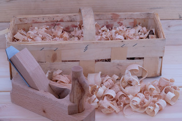 Fototapeta na wymiar Holzspähne mit Handhobel und Korb in einer Holzwerkstatt