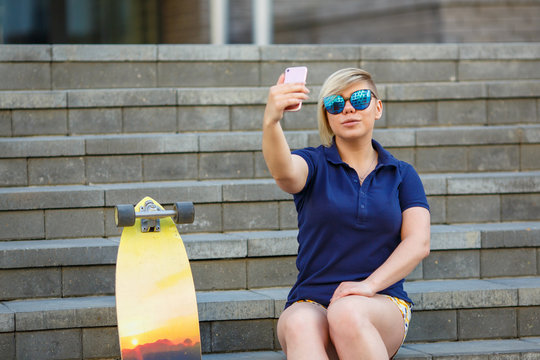 stylish girl in sunglasses takes a selfie