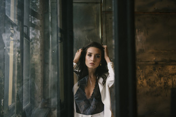 Obraz premium Young brunette woman posing in a suit by the window