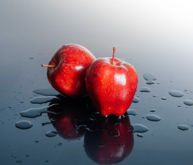 Red apple on light background With a slight drop of water with dark shadows
