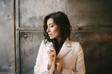 Young sexy brunette woman in jacket and pants posing in the studio