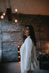 Young sexy brunette woman in jacket and pants posing in the studio