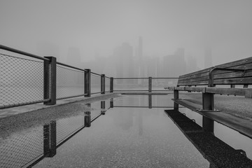 Financial district at foggy morning from the pier with reflection in black and white photo