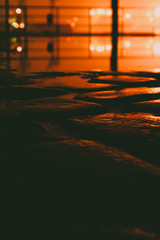 Close up of a wet cobblestone street at night with the city lights in the background