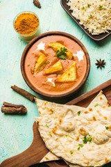 Paneer Butter Masala is a popular North Indian recipe for lunch/dinner made using cottage cheese in red tomato curry. usually served with Rice and chapati/naan. selective focus