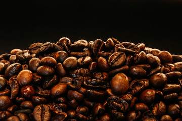 Closeup of fresh roasted coffee beans on a dark background with copy space – Natural ingredient for energy drinks with caffeine with a strong flavor and aroma