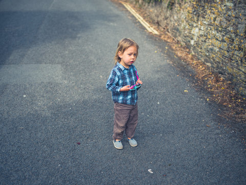 Little toddler standing in the street