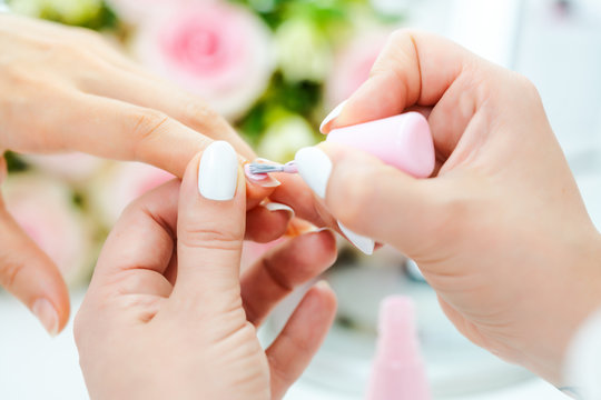 Experienced nail technician applying nail color