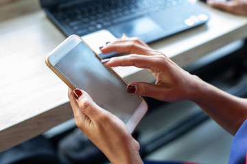 Girl's hand holding a modern smartphone and pointing with figer