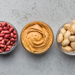 Bowls with peanut butter and peanuts