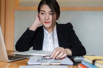 Businesswoman or accountants are working at the office to verify the accuracy of the account using a calculator and laptop computer. budget concepts.