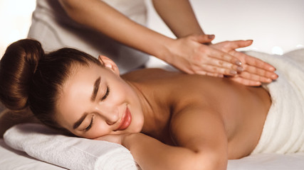 Fototapeta na wymiar Woman Enjoying Relaxing Back Massage In Spa Centre