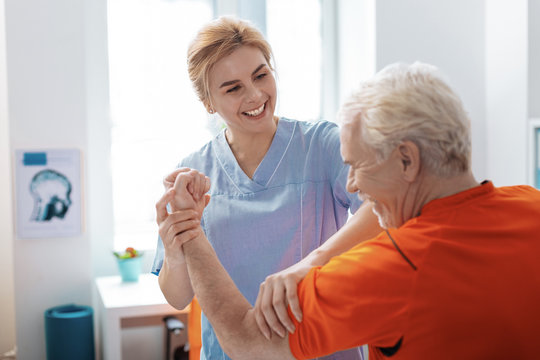 Joyful positive nurse smiling to her patient