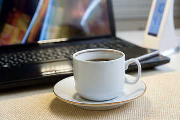 Top view of white office desk table with laptop, phone, coffee. Flat lay with empty space