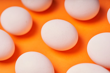 Chicken eggs laid out on an orange background