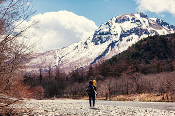 Mother carrying a boy to walk with a beautiful view and the snow capped mountains, traveller hiking on the nature park
