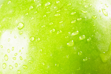 Green apple background in drops.