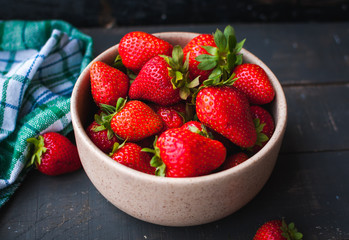 Close-up of fresh strawberries in a bowl on wooden background