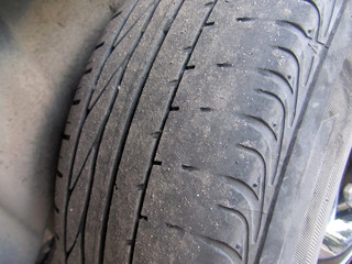 Destroyed rubber car tire. Destroyed rubber car tire close-up. Worn tread. Car repair, tire, tire replacement.