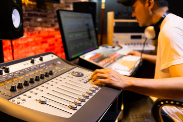 asian male professional sound engineer working in recording, broadcasting, editing studio