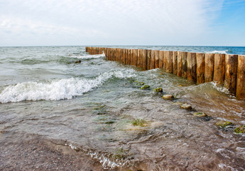 seascape with the waves crashing on breakwater