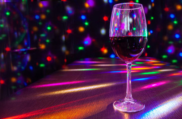 glass of wine on the table with bright festive lighting