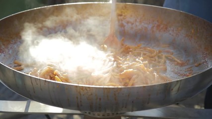 Pasta fresca fatta in casa che cucina in una grande padella da chef in alluminio