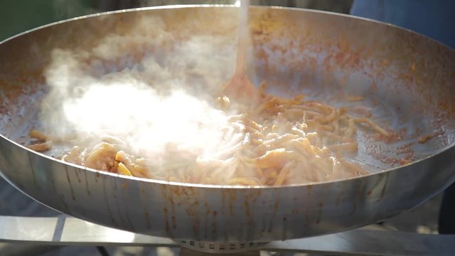 Pasta fresca fatta in casa che cucina in una grande padella da chef in alluminio