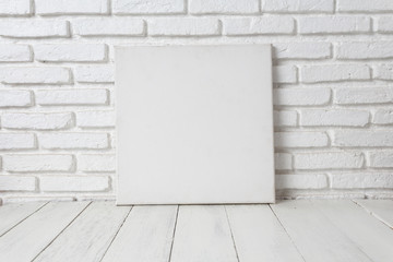 Empty white canvas frame on a wooden table