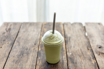 Green tea smoothies in glass on wooden table