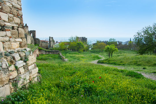 Footpath to the sea and poppies in the meadow and fortress wall of the Trigonion tower in Thessaloniki, Greece.