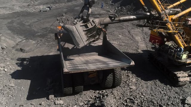 Panorama aerial view shot, open pit mine, coal mining, dumpers quarrying extractive industry stripping work. Excavator loads ground in big dump trucks.View above opencast mining with trucks