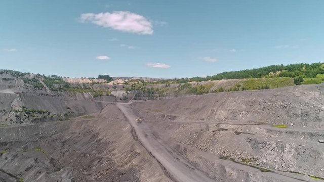 Panorama aerial view shot open pit mine coal mining, dumpers, quarrying extractive industry stripping work. Big Yellow Mining Trucks. View from drone at opencast mining with lots of machinery trucks