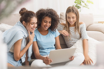 Diverse girls shopping online on laptop at home
