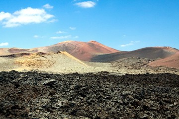 Panoramic view over lava field on crater and cone of red volcanoes in Timanfaya NP, Lanzarote,...