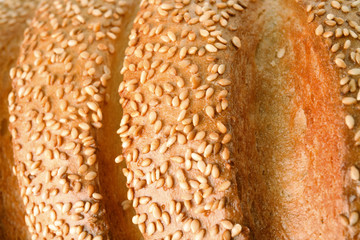 Tasty bread with sesame seeds as background, closeup