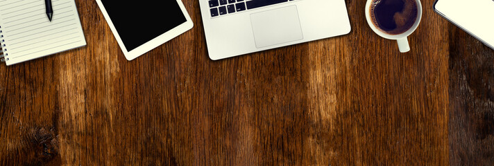 Old oak desk from above. Computer, telephone and tablet necessary tools at work. Office work in...