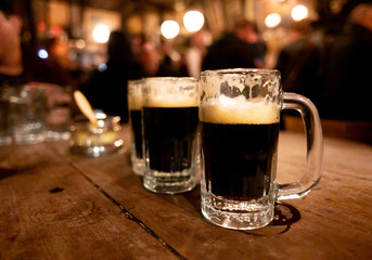 glass of beer on wooden table in historic pub