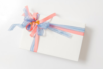 Luxury box tied with blue and pink ribbons on white background