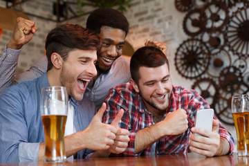 Male Friends Having Video-Call On Smartphone In Bar
