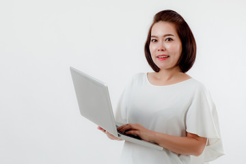 Asian beautiful woman Standing in a white shirt in her hand Holding a laptop computer Stand smiling happily With a white background