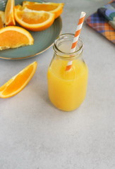 orange juice in a glass bottle and sliced orange on the table top view. copy space
