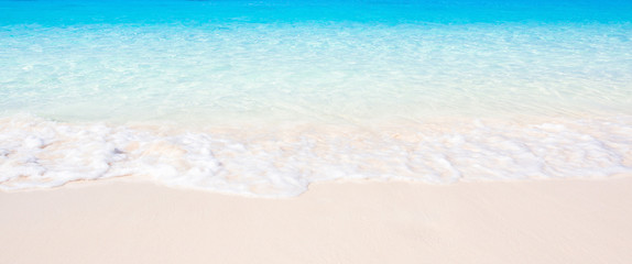 Fototapeta na wymiar Panoramic gentle ocean blue waves on a tropical beach in summer.