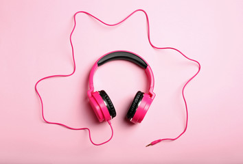 Stylish headphones on color background, top view